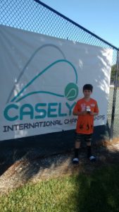 Rafael veste a camisa do Supera comemorando troféu do torneio Casely International