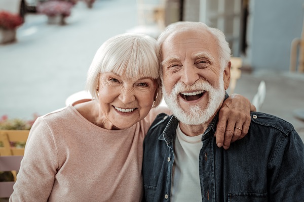Um casal de idosos abraçados e sorrindo 